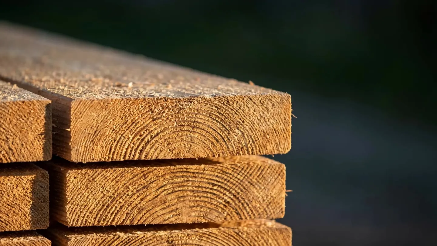 Close-up of freshly-sawn dimensional fir lumber stacked at Coldstream Lumber, showing end-grain and growth rings in warm light